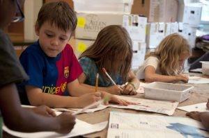 Children drawing at table with pencils. If you have a sore on your hand, the microscopic bacteria on the pencil can enter your body through the break in the skin.